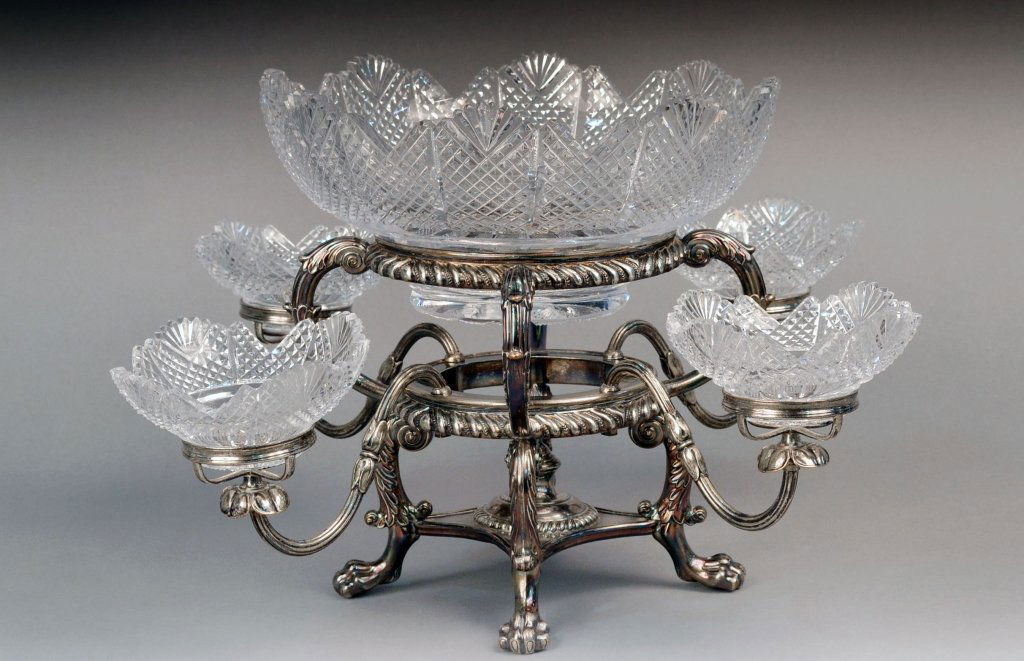 Georgian Silver Plated Epergne: Circa 1800, central glass bowl with fan cut rim and diamond cutting supported on a gadrooned basket issuing for detachable branches with scroll decoration, on scrolled legs ending on paw feet.