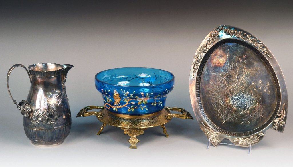 Three Vintage Table Articles: Comprising an Aesthetic and Moorish style centerpiece with an enamel decorated blue glass bowl painted with a bird on a flowering branch; together with a silver plated water pitcher and tray.