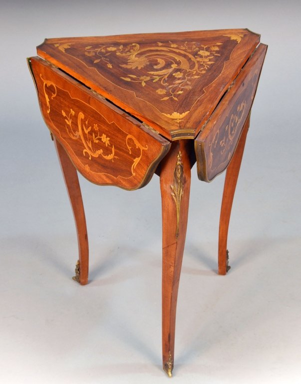 Fruitwood Inlaid Handkerchief Table: Shaped triangular top with marquetry inlaid decoration, three drop leaves, and cabriole legs with brass accents. Height 28 inches, width 29 inches, depth 29 inches.