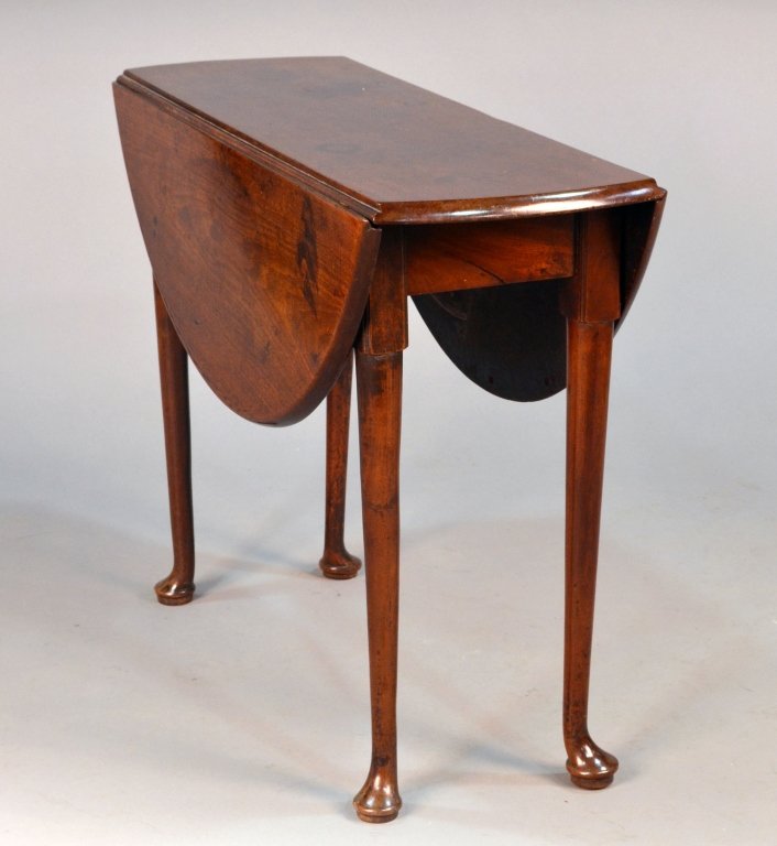 George III Mahogany Drop Leaf Table: Circular top with drop leaves on gate legs ending in pad feet. Height 28 inches, diameter open, 36 inches.