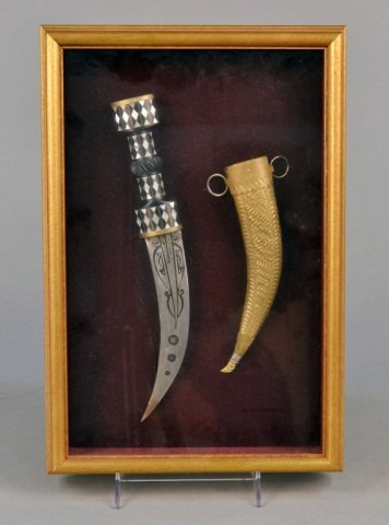 Middle Eastern Jambiya: Mother of pearl inlaid carved wood handle with brass mounts, the single edged blade with etched calligraphy and stylized geometric decoration, the brass scabbard with repousse and wire wrap decoration
