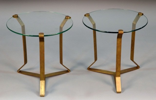 Pair of Glass Top Bronze Tables: Circular tops on three bronze supports joined by a shaped stretcher. Height 20 inches, diameter 20 inches.