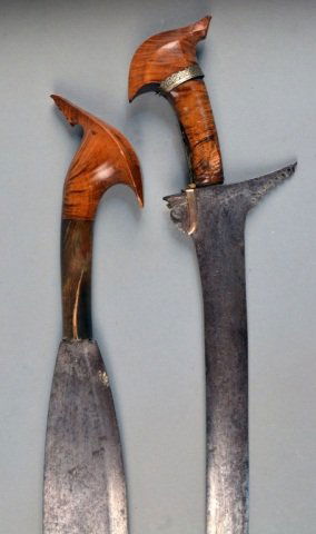 Two Ethnic Short Swords: One an Indonesian Kris with hardwood pommel with mixed metal band decoration, blade length 21 1/4 inches; the other probably african, with a single edge ovoid blade and hardwood and horn handle, blade