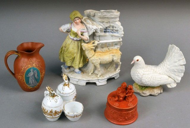 Group of Five Continental Decorative Arts: Circa 1865-1900. Comprising a Heubach Gebruder enameled bisque figural vase, circa 1900, height 10 1/4 inches; a Victorian redware small ewer, design registered in 1866, decorated with an allegorical