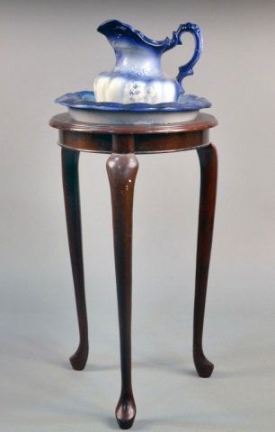 Two Pitcher and Basin Sets: One, white glazed porcelain; the other blue and white glazed porcelain. Together with a tall wood stand. Overall height 44 inches. Provenance: Estate of Leo Barrile, Leo's Antiques in Bensonhurst NY