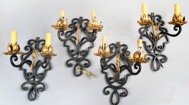 Set of Four Wrought Iron Two Arm Sconces: Each with painted and parcel gilt, scroll decorated backplate and arms. Height 13 inches, width 10 inches.
