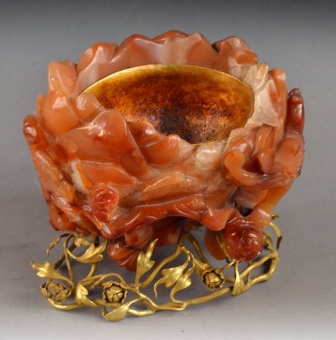 Carved Carnelian Bowl: Carved flower and bird decoration, on a gilt metal flowering vine base. Height 5 inches.