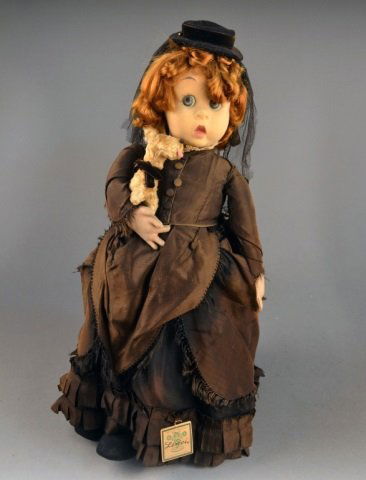 Lenci "Widow Allegro" Doll: Circa 1960, wearing a brown taffeta dress and holding a small dog, original paper label. Height 21 inches.