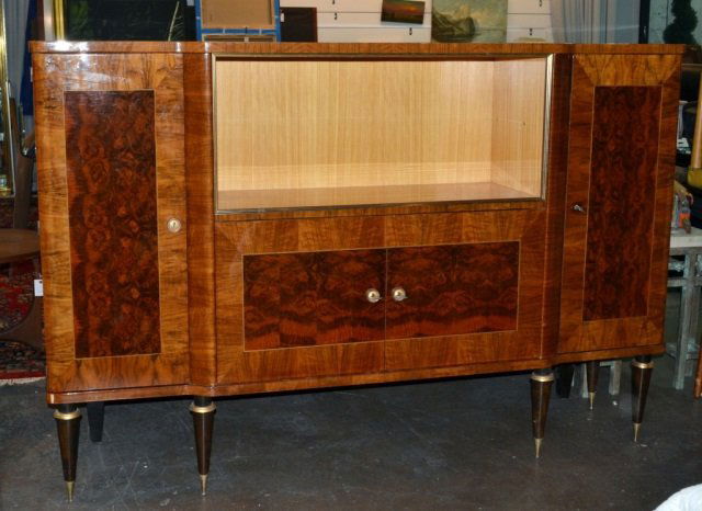 French Art Deco Cabinet: Circa 1940s. Rosewood and burl mahogany veneered. Shaped rectangular top above two open shelves and a two door cabinet, flanked by two single door cabinets, all on conical legs. Height 56 inches, widt