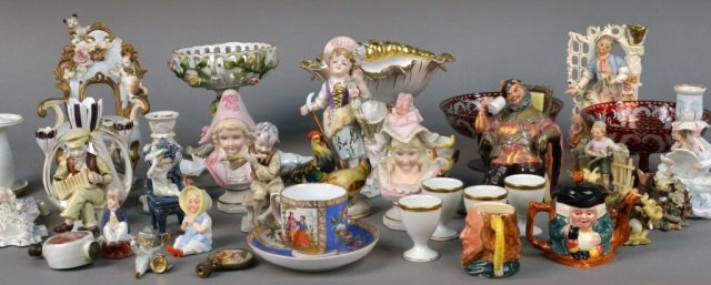 Group of Table Decorations: Including Royal Doulton porcelain character figures, pair of flashed glass compotes, porcelain figural vases, set of four egg cups, Dresden porcelain compote, etc. Compote, height 6 inches.