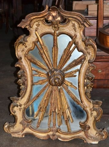 Rococo Style Gilt and Painted Wood Mirror: Cartouche shaped with scroll and shell decoration and a radiating central floral rosette. 40 x 26 inches.