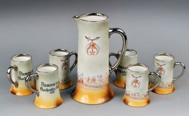 Thomas Maddock's Son's Co. Set of Mugs: Set of six mugs along with matching pitcher. All painted with Masonic motif. Pitcher height 12 1/2 inches, mug height 5 1/2 inches.