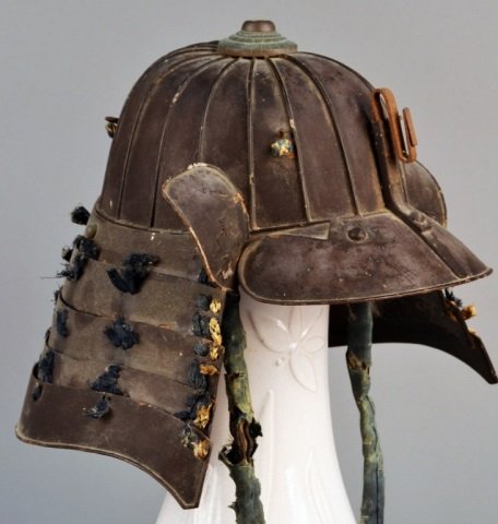 Japanese Samurai Kabuto Helmet: Edo period, lacquered metal with a dome (hachi) consisting of eighteen interlocking plates and a five stage neckguard (shikoro).