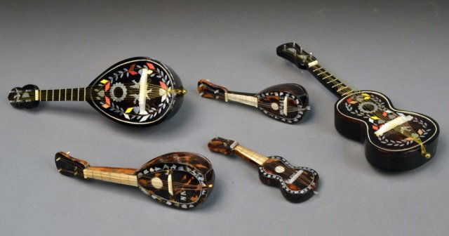 Group of Miniature Musical Instruments: Comprising a guitar, mandolin, lute, ukalele, etc., three with mother of pearl, bone and tortoise shell inlay, two with metal and enamel inlay and music box interior. Largest length 10 inches.