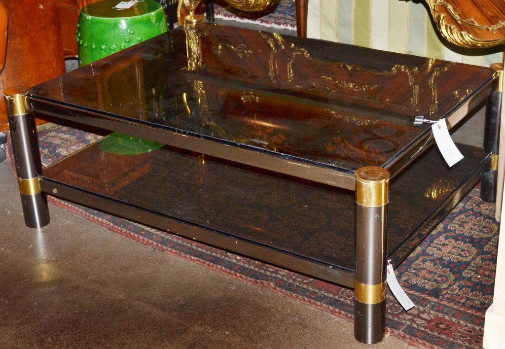 Karl Springer Two Tier Table: Metal and brass frame with inset rectangular glass top, four cylindrical legs joined by a conforming glass shelf. Height 17 inches, width 36 inches, depth 48 inches.