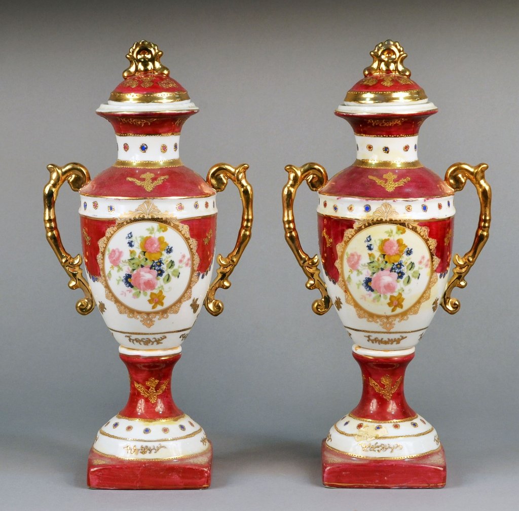Pair of Vienna Style Porcelain Covered Urns: Floral decoration, claret round, gilt highlights. Height 17 inches. Provenance: Estate of Leo Barrile, Leo's Antiques in Bensonhurst NY