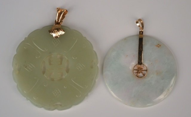 Two Jade Pendants: Both 14k yellow gold mounted, one with scalloped edge and pierced center; the other with a central Asian character decoration. Larger, diameter 2 1/4 inches.