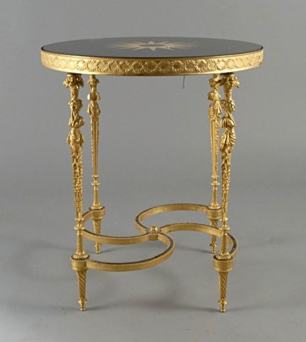 Gilt Bronze Gueridon: Circular stone/marble top, four tapered gilt bronze legs joined by a fancy X stretcher. Height 27 inches,diameter 24 inches. Note: Being sold to benefit Fordham University, -received by the university