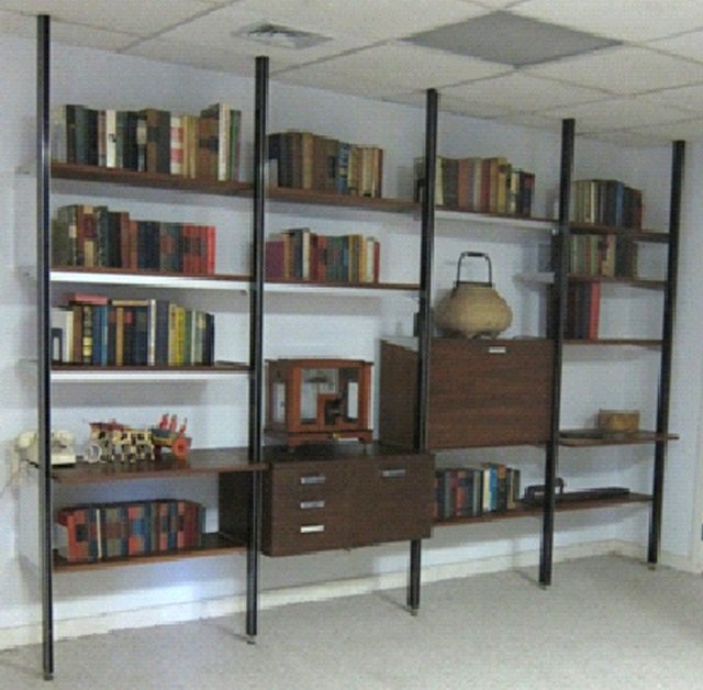 George Nelson Mid Century Omni Unit Bookcase: Metal supports with brown shelves on brushed metal supports. Adjustable. As shown height 8 feet 2 inches, width 10 feet 9 inches, depth 18 1/2 inches.