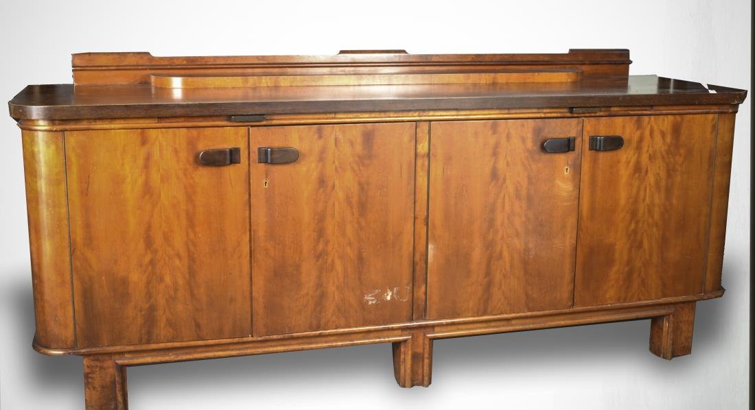 Art Deco Style Mahogany Sideboard: Rectangular top with back splash and rounded front corners above two brushing slides and two two-door cabinets opening to shelves and a bank of two short drawers, all on conforming block feet. Height 