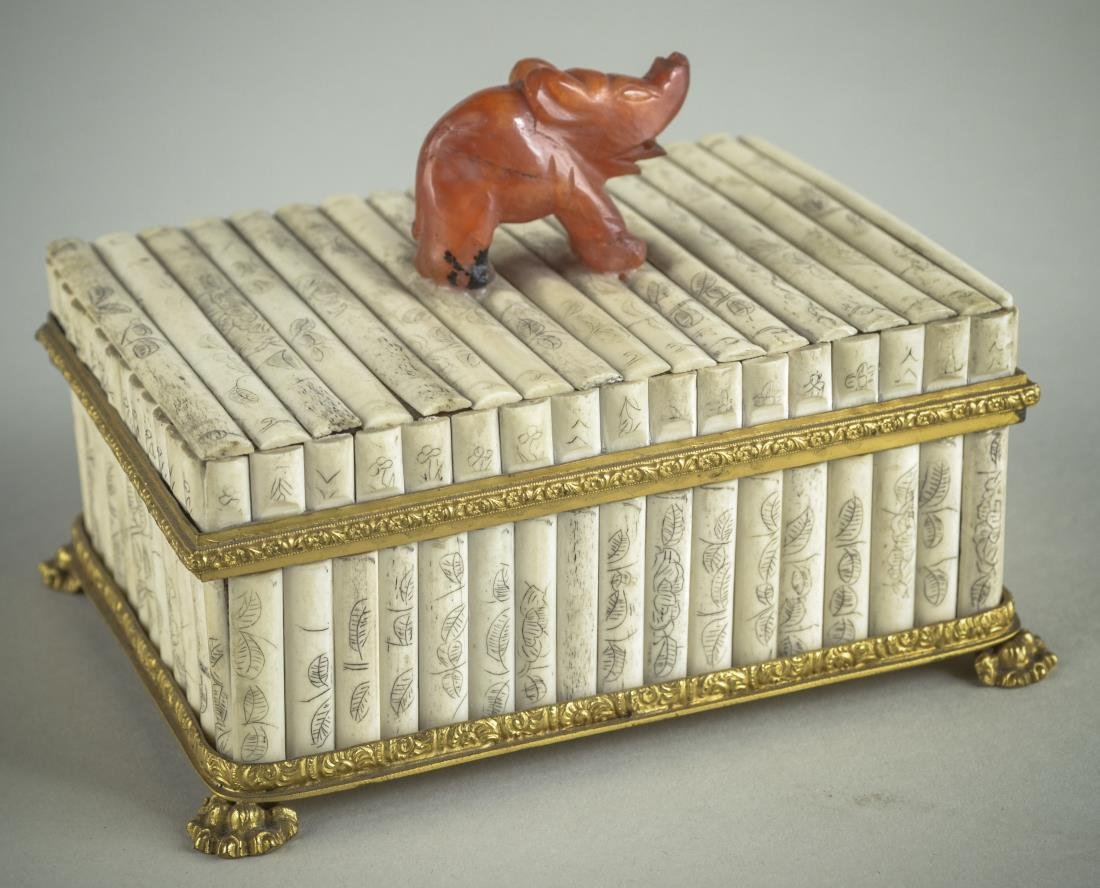 Nicholas Haydon Ivory Box: Bronze mounted box with carved decoration and mounted with a carnelian elephant. Height 4 1/4 inches, width 5 /12 inches, depth 4 1/4 inches.