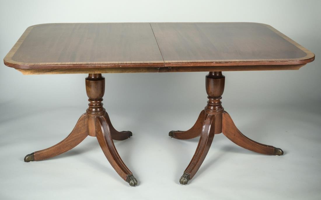 Regency Style Mahogany Dining Table: Rectangular crossbanded top on two pedestal bases with an additional leaf. Height 29 inches, length extended 6 feet 10 inches, width 43 inches.