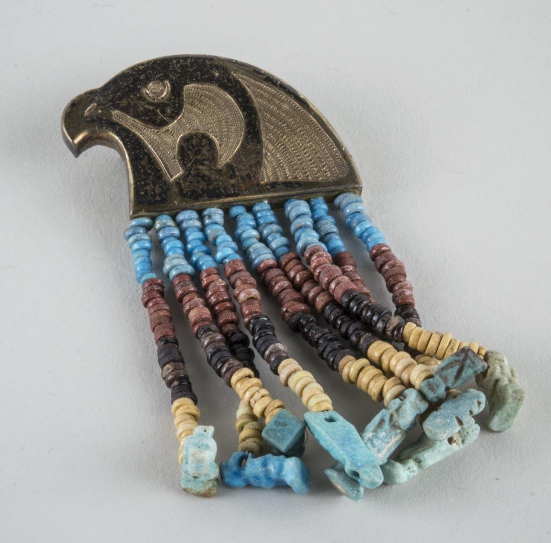 Egyptian Mummy Bead Jewelry: Patinated metal head of Horus with mummy bead fringe. Height 4 inches.