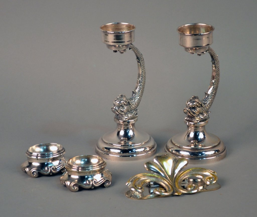 Group of Silver Plated Decorations: Pair of silver plated dolphin candlesticks, a pair of Continental silver salt cellars and a silvered brass letter holder. Candlesticks, height 8 3/4 inches.