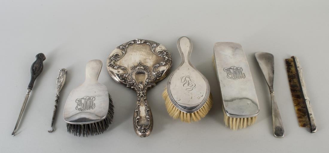 Group of Sterling Silver Dresser Articles: Including two Wallace brushes, an American sterling hand mirror and comb set, an Alvin hair brush, also two button hooks and a shoe horn. Mounted and weighted.