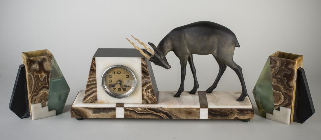 Art Deco Clock Garniture: Comprising a marble clock mounted with a deer and a pair of matching marble vases. Clock, height 12 inches, length 21 inches, depth 5 inches.