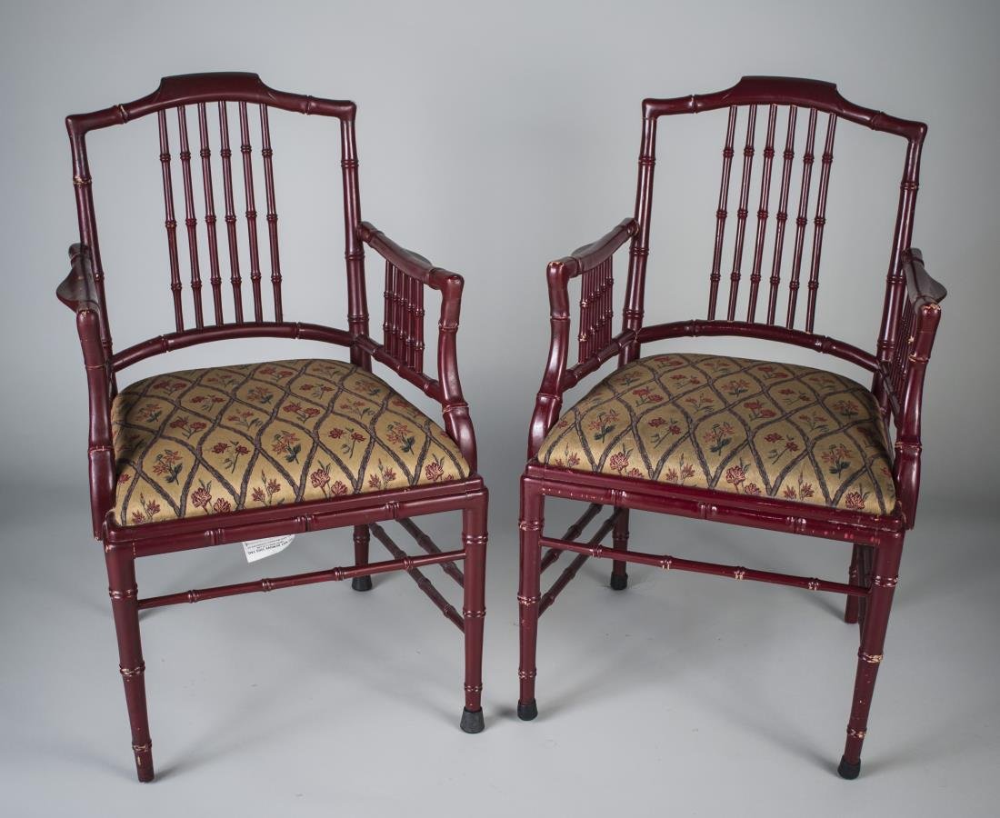 Pair of Faux Bamboo Armchairs: Each wine painted chairs with open back and arms, upholstered seat and faux bamboo legs joined by a box stretcher. Height 37 inches, width 24 inches, depth 23 1/2 inches