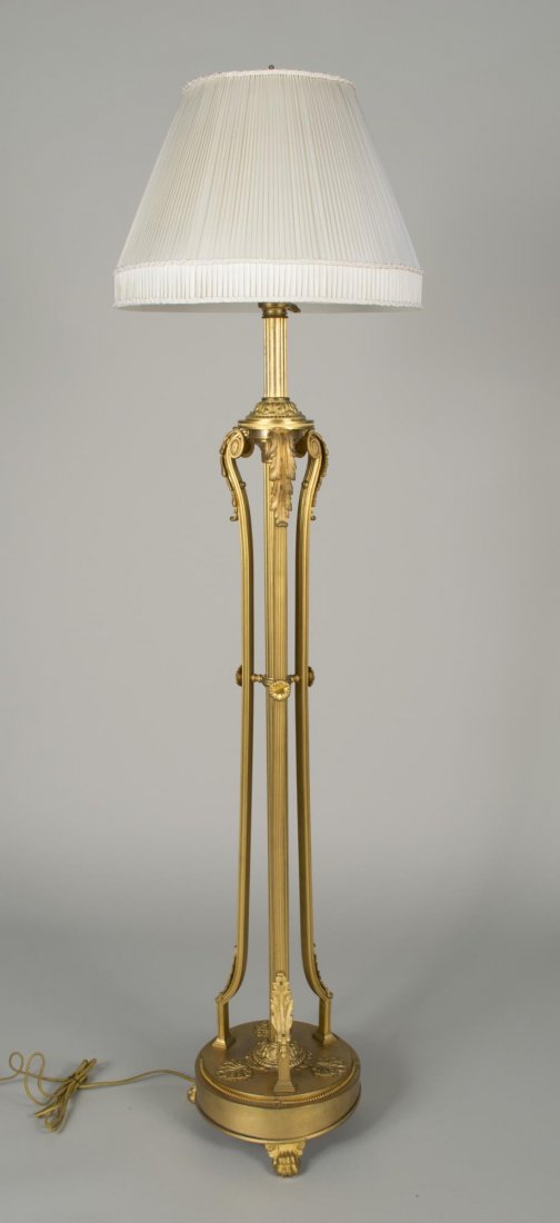 Neoclassical Style Bronze Floor Lamp: With a fluted column center support surrounded by three scrolled supports with acanthus leaf decoration on a round base with three paw feet. Height 63 inches.