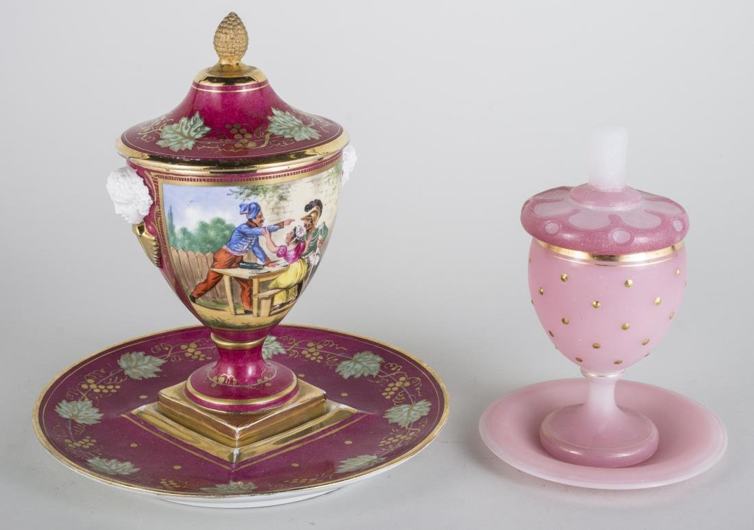 Sevres Porcelain Urn with Undertray: Decorated with a scene of a courting couple on claret ground; together with a pink opaline glass covered urn with undertray. Sevres urn, height 9 3/4 inches.