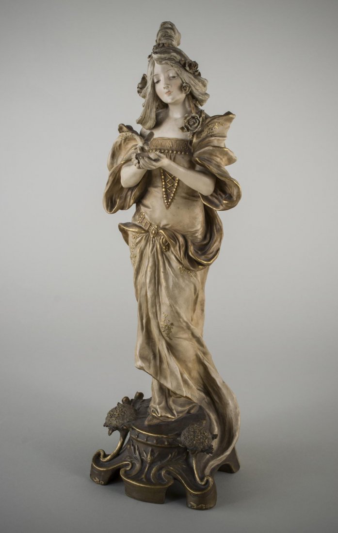 Amphora Porcelain Figure: Woman standing, a bird feeding out of her hands. Height 18 inches.