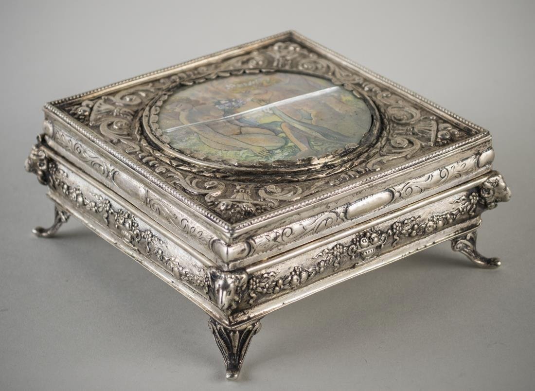 Continental Silver Portrait Box: 19th century, square, neoclassical style, the top inset with a watercolour of two nymphs bathing, within a border of leafy scrolls, rams head corners and scroll feet. Height 2 1/4 inches, 5 inches squ