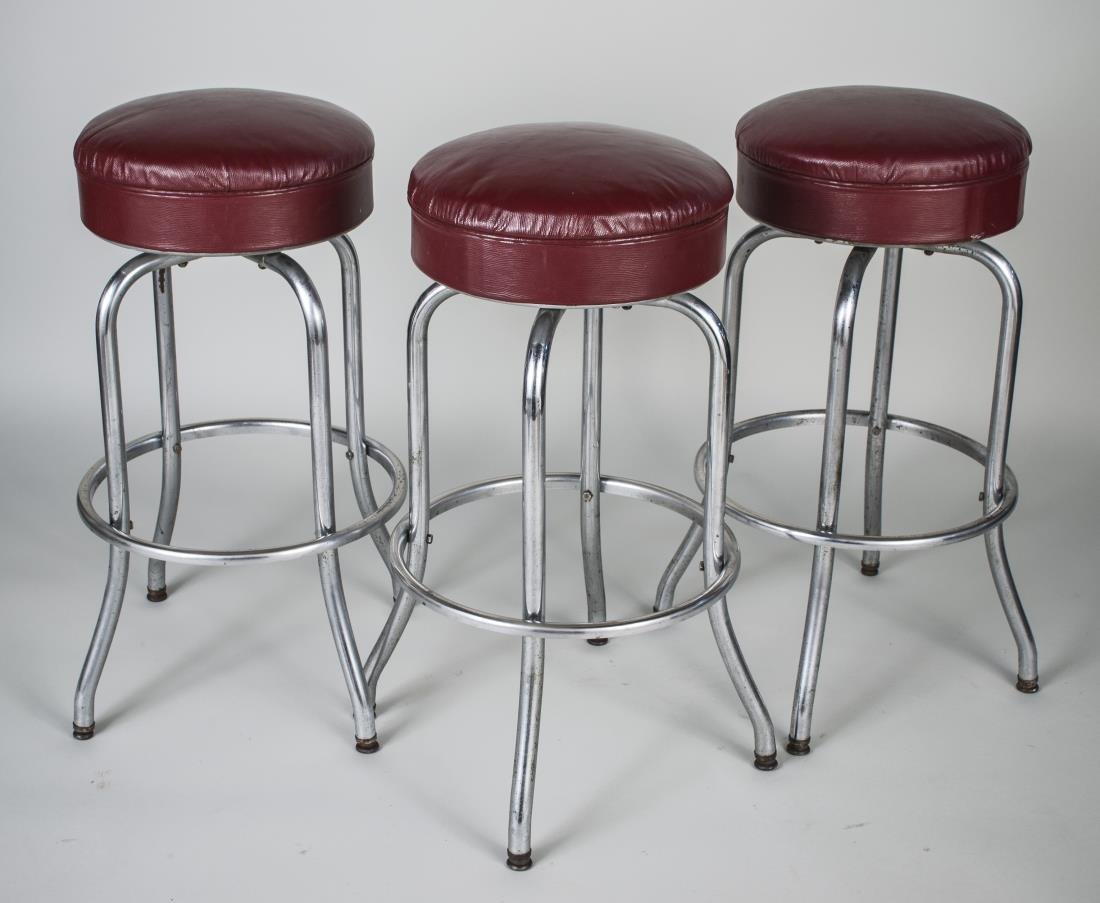 Three Chrome Bar Stools: Each with brown faux leather upholstered seat on a tubular metal frame. Height 31 inches, diameter 19 inches