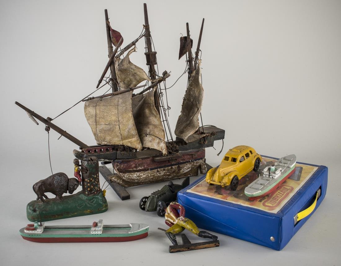 Miscellaneous Group of Toys and Models: Including a collection of Matchbox cars, two cast iron cars, a cast iron coin bank, three wood ship models, and an articulated carved wood figure.