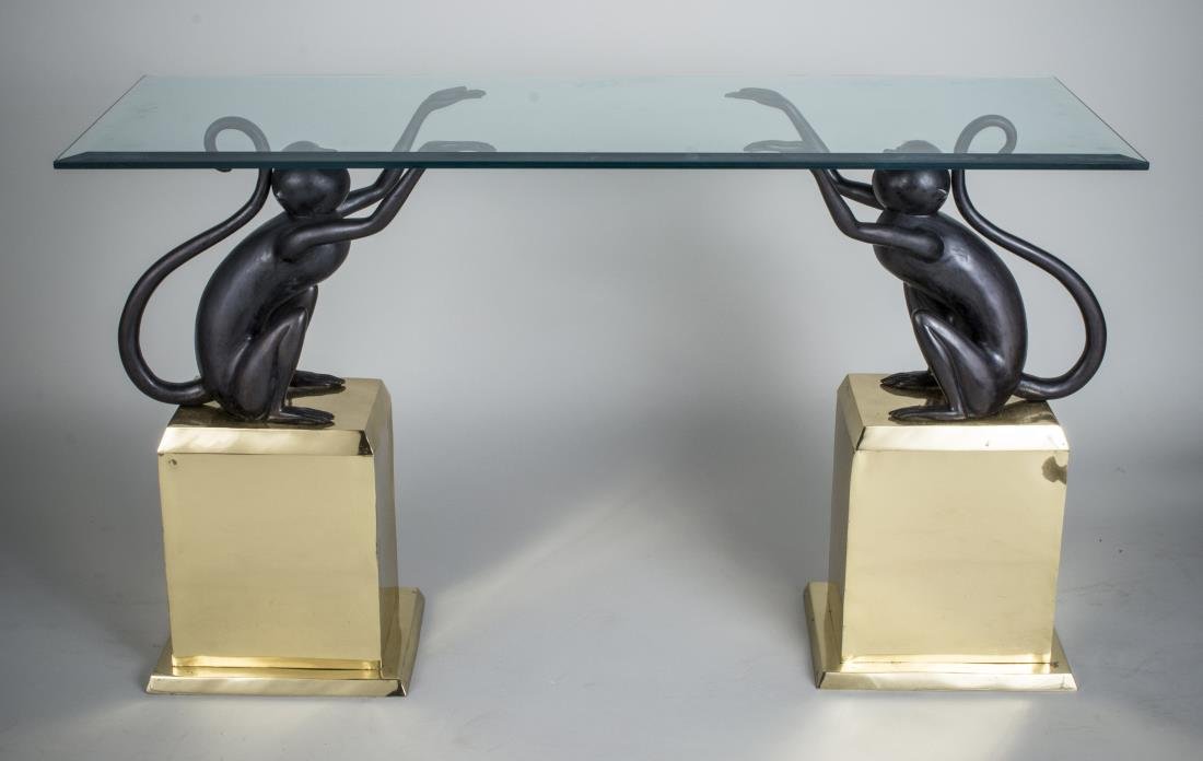 Glass Top Console Table: Rectangular glass top with beveled edge, supported on two monkey figural bases. Height 30 inches, width 48 inches, depth 18 inches.