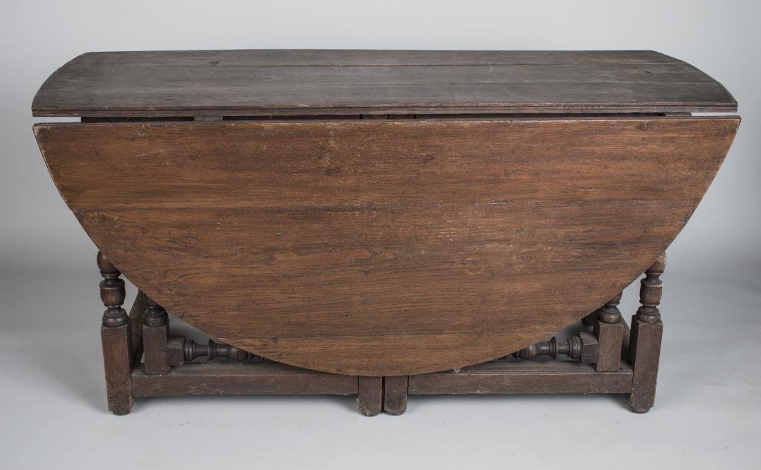 George II Style Drop Leaf Gate Leg Table: Rectangular top with D shaped drop leaves, turned legs joined by a box stretcher. Height 29 inches, width 56 inches, open length 6 feet 1 inch.