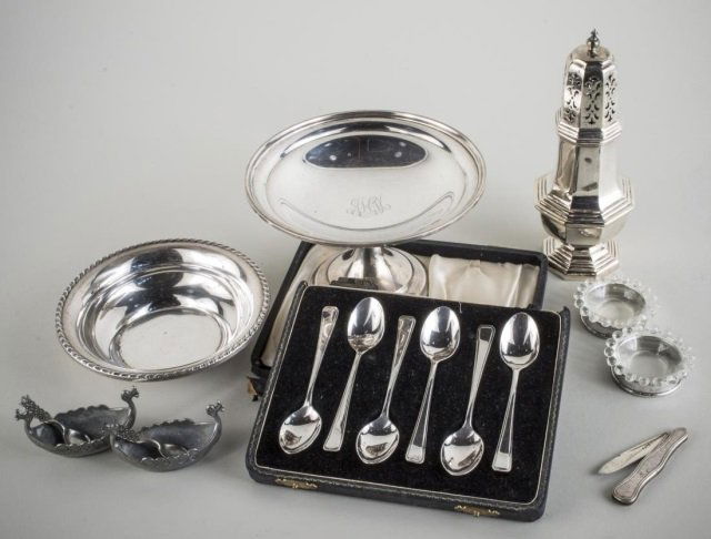 Group of Silver Table Articles: Including a boxed set of six English silver coffee spoons, weighted compote, pair of sterling silver napkin rings, sterling silver candy dish, silver plated muffineer, etc.
