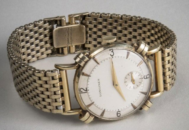 Gentleman's Gold Longines Wristwatch: 14k yellow gold wristwatch, white dial with Arabic quarter hours and baton hours, gold tone band. Length 7 1/4 inches.