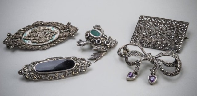 Group of Marcasite Jewelry: Four brooches and a frog pendant.