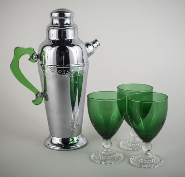 Art Deco Cocktail Set: Including a chrome shaker/pitcher with translucent green bakelite handle, and three green glass cocktail glasses.