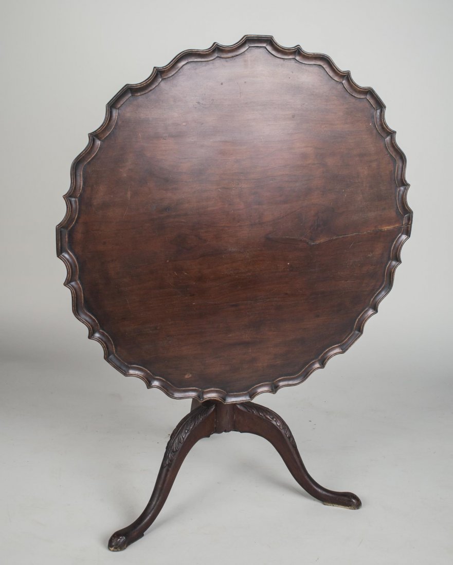 George III Mahogany Tilt Top Table: 19th century, piecrust top with scalloped rim, on a turned support with tripod legs ending in pad feet. Height 28 inches, diameter 35 inches