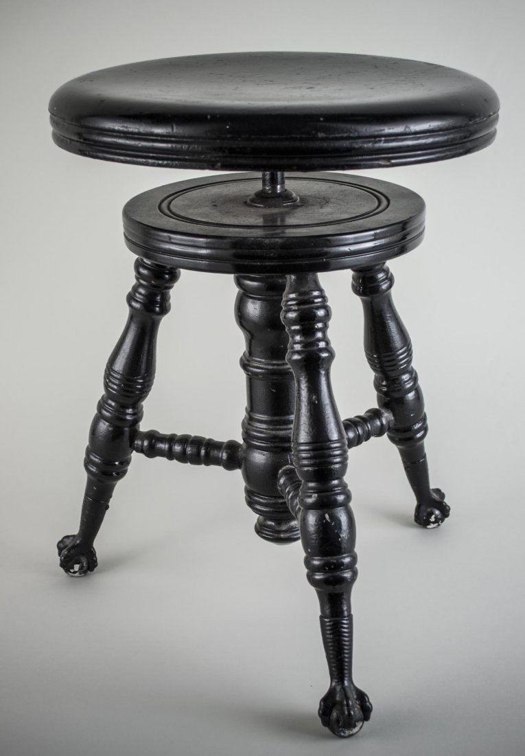 Victorian Piano Stool: Black painted stool with revolving seat, on turned legs ending in claw and glass ball feet. Adjustable height.