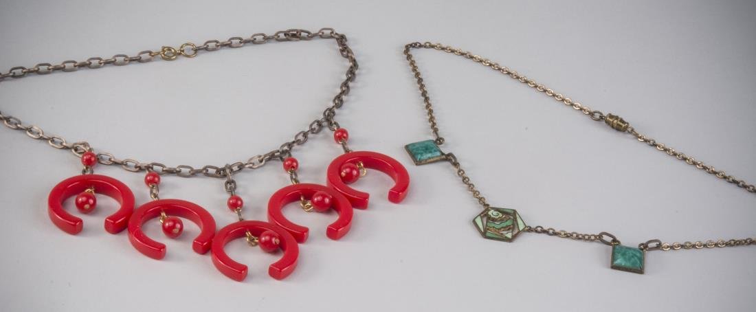 Two Art Deco Necklaces: Circa 1930, one a metal chain suspending five red three-quarter circles with ball accents, length 16 inches; the other, a neck chain with two simulated jade square drops centering an enamel pendant, l