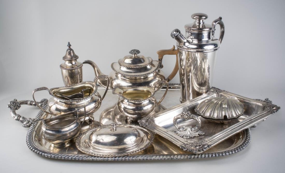 Group of Silver Plated Table Articles: Three piece tea set, cocktail shaker, caster, serving tray, etc. Tray, length over handles, 28 inches. Notice to bidders: Condition reports and additional photographs are provided by request as a cour