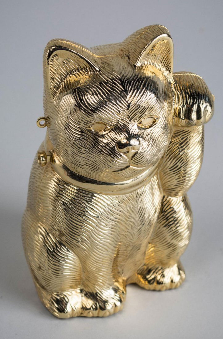 Judith Leiber Gold Tone Purse: In the form of a sitting cat with a raised paw, includes shoulder chain. Measures 5 1/2 inches tall. Notice to bidders: Condition reports and additional photographs are provided by request as a courte