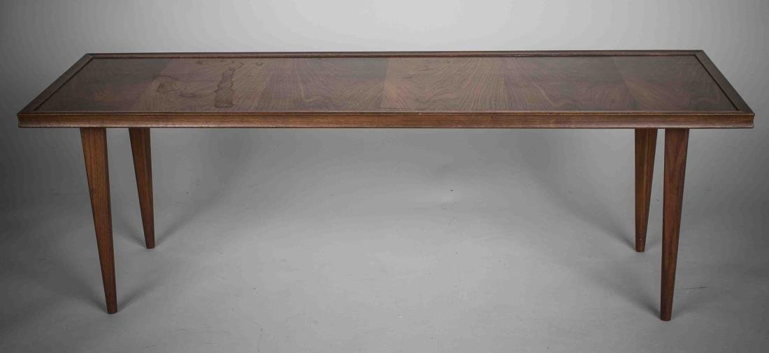 Modern Wood Coffee Table: Rectangular top on square tapered legs. Height 19 inches, width 56 inches, depth 18 1/2 inches. Notice to bidders: Condition reports and additional photographs are provided by request as a courtesy to