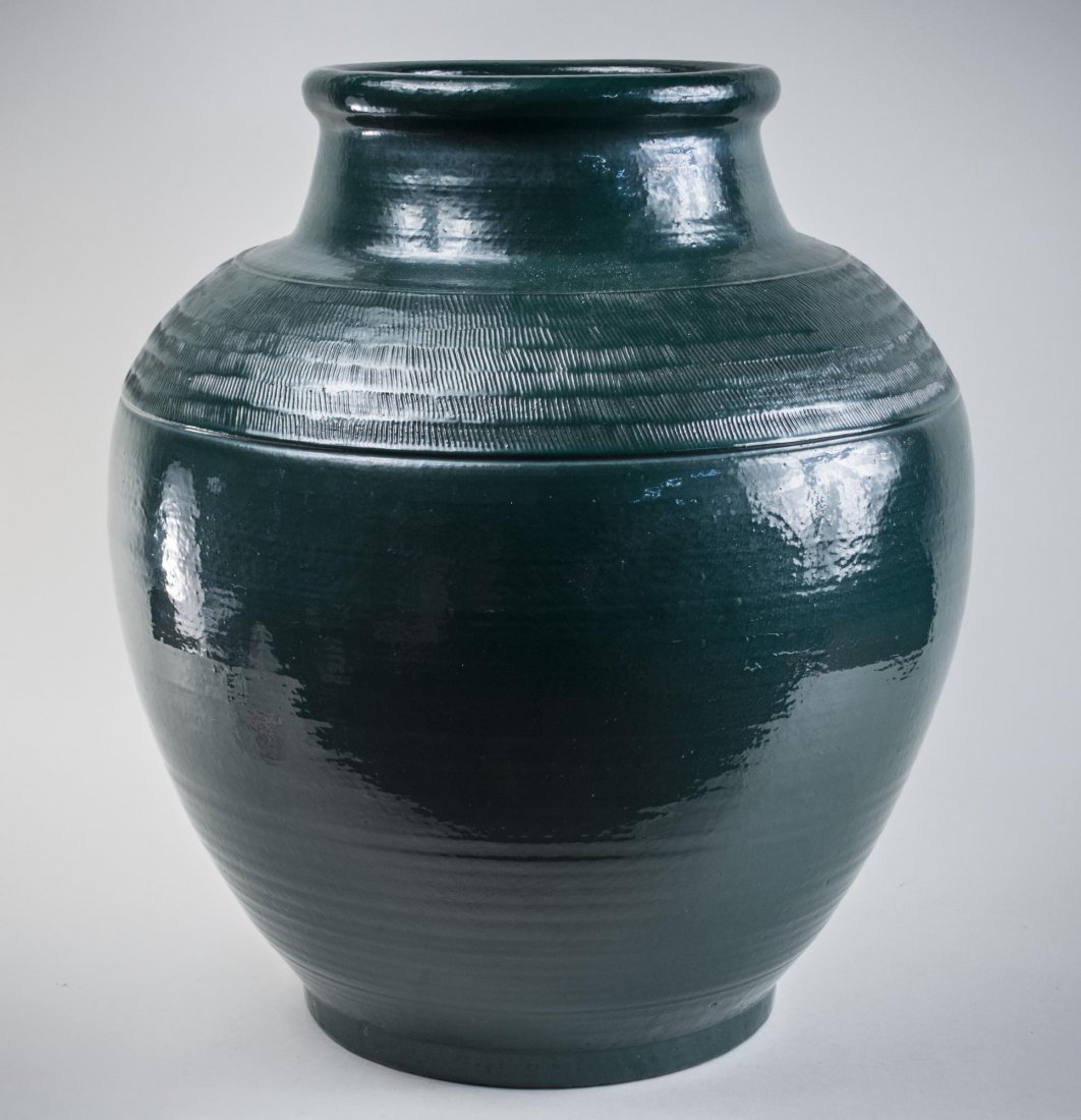 Monumental Green Ceramic Vase: Ring rim, cylindrical neck and ovoid body with incised decoration on the shoulder. Height 24 inches. Notice to bidders: Condition reports and additional photographs are provided by request as a courte